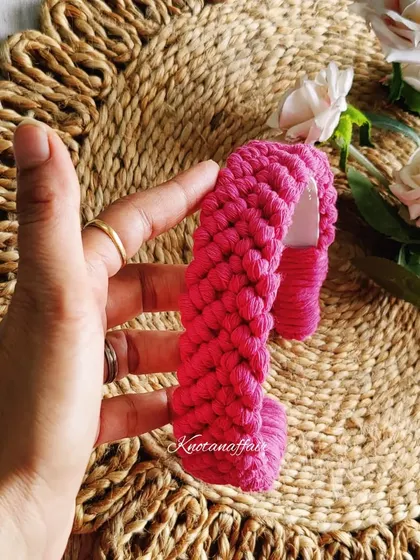 This intricately handcrafted macrame hairband in a vibrant pink is a unique accessory that is sure to elevate your look.