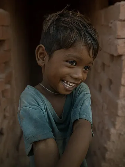 The bright, genuine smile of a child at a brick kiln in Bihar. This portrait is a reminder of the happiness and innocence that can be found even in the harshest of environments.