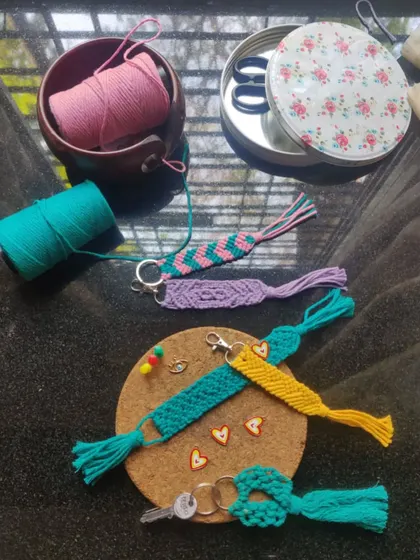 Our macrame workstation, showing how we prepare our handmade keychains and bag charms. You can see the different colors and patterns we work with to create these pieces.
