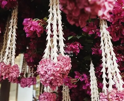 A detailed view of hanging floral tassels, made from bougainvillea and jasmine, used to create a stunning entrance arch.