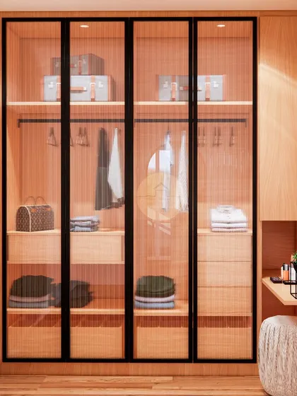 A beautiful and functional walk-in wardrobe with fluted glass doors and black metal frames. The interior is well-organized with shelves for luggage, hanging space, and multiple drawers for folded clothes and accessories.