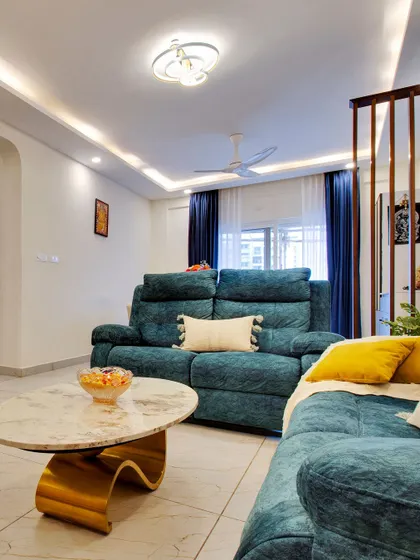 A cozy shot of the living room seating, showing the plush sofa and a modern coffee table with a sculptural gold base.