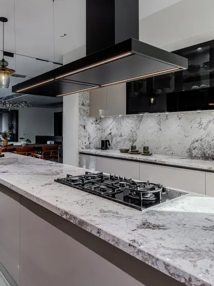 A detailed shot of the Brazilian granite countertop, showing its unique veining and texture. This natural stone adds a layer of organic beauty to the highly modern design.