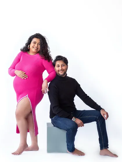 A confident and happy portrait. The combination of the bright pink dress and the clean white background is modern, fresh, and full of joy.
