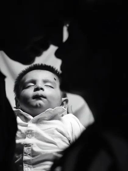 A silhouette-style black and white photo of parents and their newborn, creating a powerful and artistic family portrait.