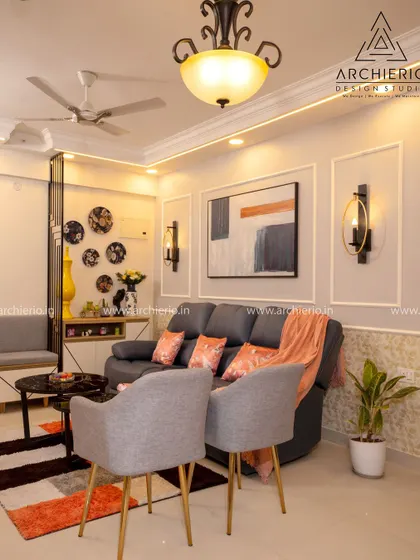 A comfortable living room with a grey recliner sofa and pops of peach and orange in the decor. The space is modern, functional, and has a welcoming feel.