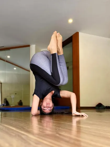 You can't use up creativity. This student works on a tucked headstand, a core-intensive variation that builds stability.