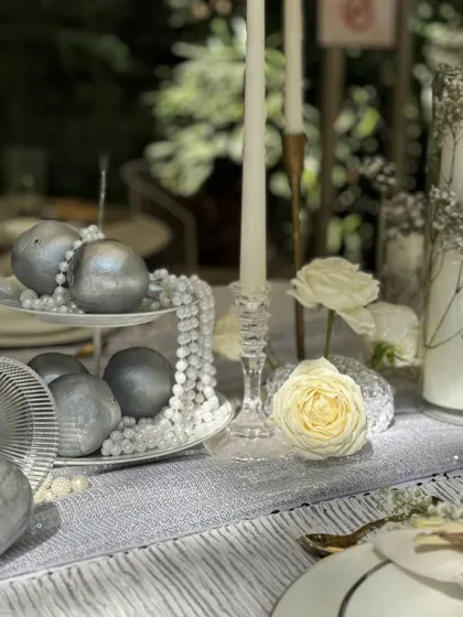 Silver-painted pomegranates and cascading pearl strands create a unique and opulent centerpiece, blending natural forms with luxurious finishes.