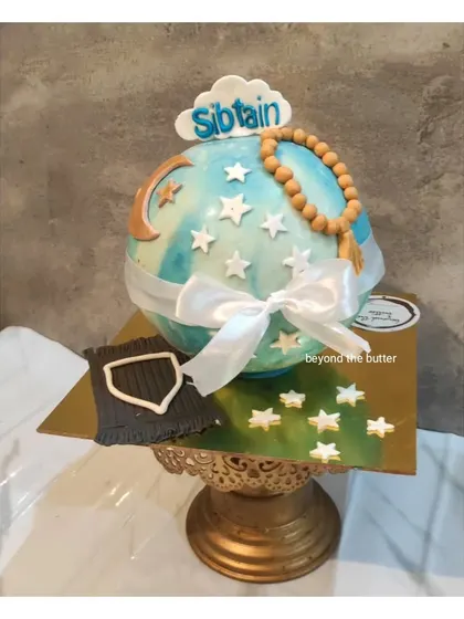 A Ramadan Mubarak pinata cake. This spherical cake is decorated with a crescent moon, stars, and a tasbeeh, and is filled with sweet surprises.