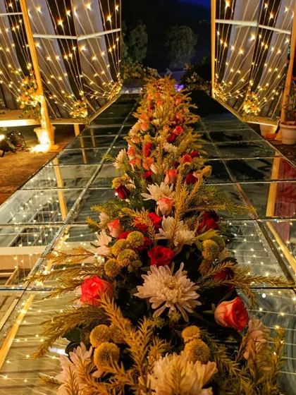 A truly unique and glamorous wedding aisle. I created a raised glass floor with floral arrangements and fairy lights underneath, allowing the bride to walk on a path of light and flowers.