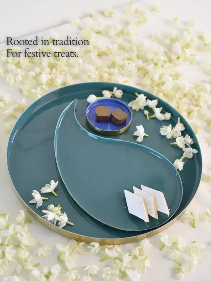 Rooted in tradition, for festive treats. This teal tray, inspired by the paisley or 'ambi' shape, is another piece from our Symbols of Celebration collection, shown here serving a mix of Indian sweets.