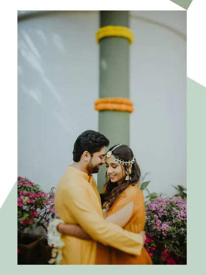 An intimate portrait of the couple embracing during their Haldi ceremony, surrounded by flowers.