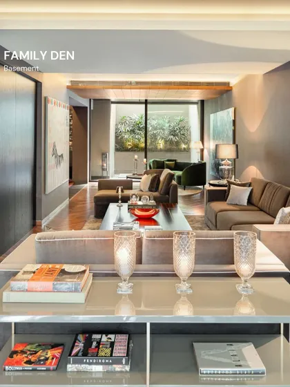 The family den in the basement of the Vasant Vihar home is a cozy retreat. The design uses darker tones and comfortable, deep seating to create an intimate space for relaxation and entertainment.