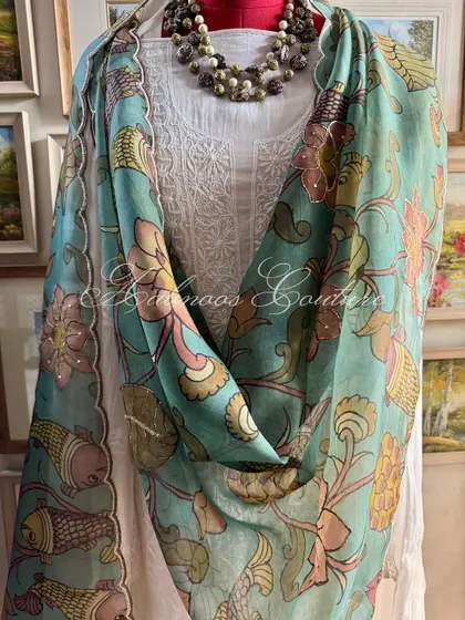 A styled shot that emphasizes the beautiful contrast between the vibrant Kalamkari art and the serene white Chikankari, a signature pairing of our couture house.