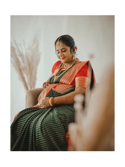 This image captures the gentle and loving moments of a maternity shoot, with makeup that enhances her natural beauty.