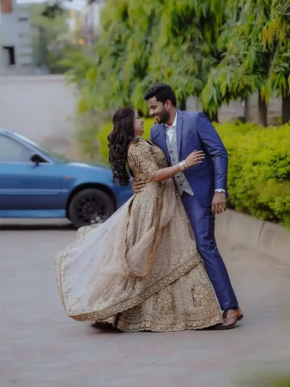 A dynamic shot of a couple dancing, the bride's ornate lehenga swirling around her.
