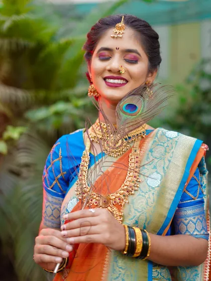 This portrait captures a moment of serene bliss. With her eyes closed and a gentle smile, the bride looks completely at peace. The peacock feather adds a soft, delicate touch to this beautiful bridal shot.