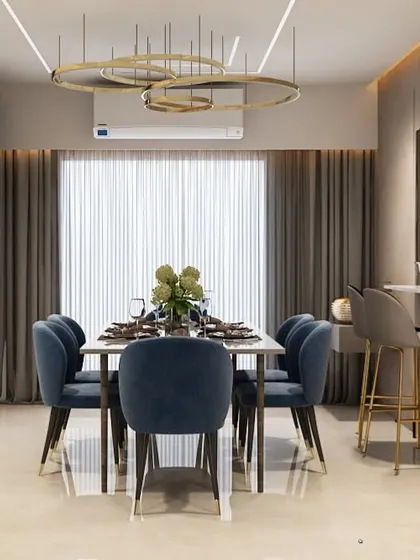 A modern dining area with an adjacent breakfast bar. The dark blue chairs and ring-style chandelier add a touch of drama and sophistication.