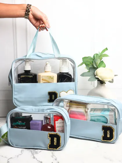 Our set of 3 clear-view wash bags in a lovely powder blue. Each bag is personalized with a black and gold chenille "D" patch, making it a stylish and practical set for travel.