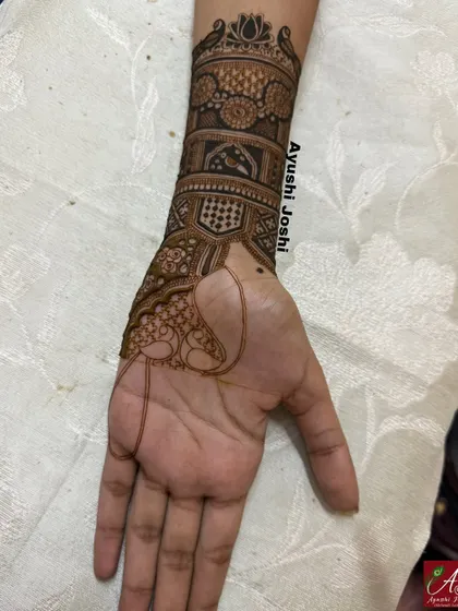A view of the arm band being created for this engagement design, showing the half-finished peacock and the intricate patterns taking shape.