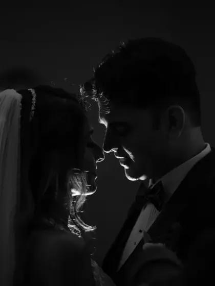 A dramatic, rim-lit silhouette of the couple. This artistic black and white shot is perfect for creating a moody and romantic wedding portrait.