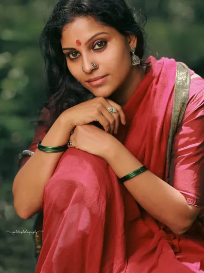 A rustic, village-themed series inspired by the movie 'Kanthara'. The model is styled in a simple red saree, captured in a natural, watery landscape to evoke a sense of raw, earthy beauty.