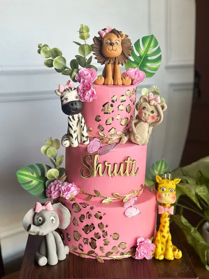 Step into the wild with our pink and gold safari-themed cake. This three-tiered creation is adorned with cute, handcrafted jungle animals and chic leopard print details for a stylish adventure.