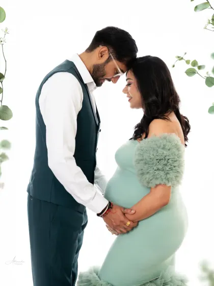 A quiet moment of connection. We posed this couple against a simple, bright background to let their love and the beauty of the mint green gown truly shine.