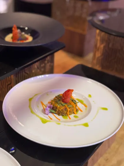 Another example of our artistic plating, where a savory main is garnished with a vibrant red element and a drizzle of green oil. Each component is placed with intention to create a balanced and beautiful dish.