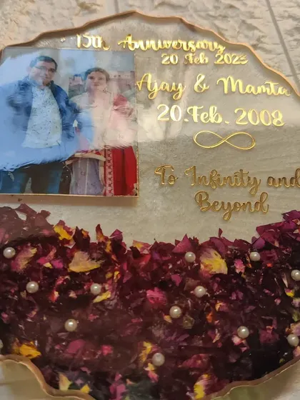 A 15th-anniversary celebration, immortalized in resin. This plaque features the couple's then-and-now photos, their original wedding date, and the anniversary date, all surrounded by their preserved flowers.