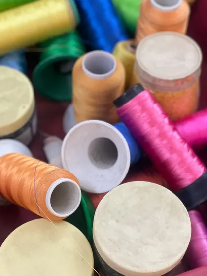 A vibrant collection of threads and beads ready for the "Gauri Series." The bright pinks, oranges, and yellows are essential for capturing the vivid colors of traditional Pichwai art.