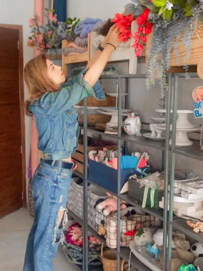 My studio is filled with props and flowers to create unique setups. Here I am arranging florals on my prop shelf before a session.
