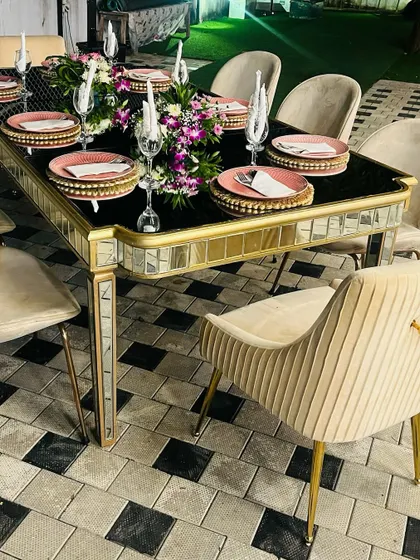 A closer look at our mirrored and gold-accented dining table. The combination of the reflective surfaces, black tabletop, and plush seating creates a look of pure glamour and sophistication.