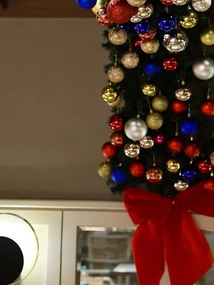 A close-up of a Christmas garland, finished with a large red bow. It's a classic touch that instantly says 'festive'.