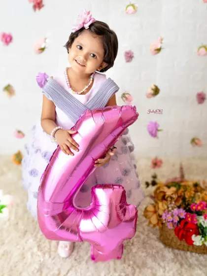 A big number four balloon for the birthday girl. The falling flower petals add a touch of magic to this sweet fourth birthday portrait.