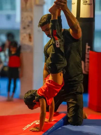 A young boy learns the fundamentals of a handstand with the help of his coach. We build skills progressively, ensuring every child develops a strong and safe foundation in gymnastics.