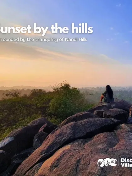 A guest watches a breathtaking sunset from a rocky outcrop at Nandi Hills, a truly magical and tranquil experience.
