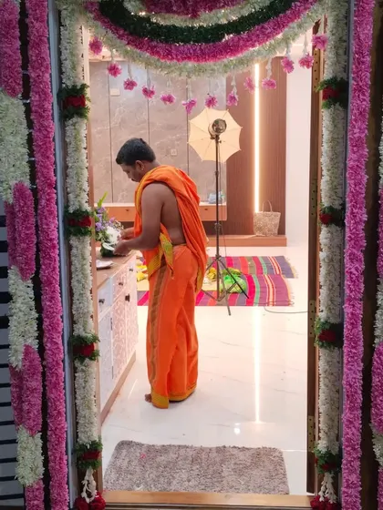 This image shows the floral door decoration during the housewarming ceremony itself, with the priest performing the rituals inside. It shows how my decor becomes the backdrop for the most important moments of your event.