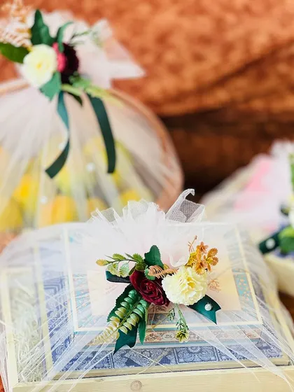 A close-up of a gift box from a trousseau set. The intricate floral arrangement on top, with a mix of flowers and leaves, shows the level of detail in my work.