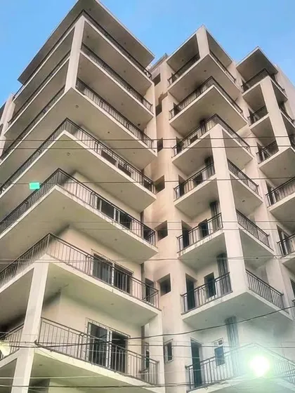 The facade of a multi-story residential apartment building. The design uses repeating geometric patterns in the balconies to create a striking and cohesive look.