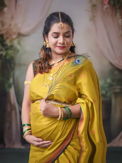 We incorporate meaningful props into our traditional shoots, like this peacock feather, which adds a symbolic and artistic touch to this beautiful saree portrait.