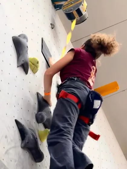 A young woman races up the wall during the Speed Climbing competition. This event is a great entry point for new climbers to experience the thrill of competition.