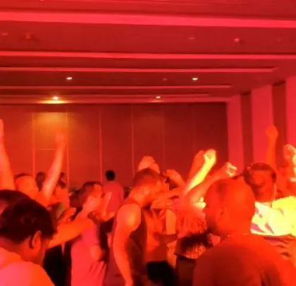 The room is bathed in red light as the employees dance.