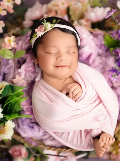 A precious, fleeting smile from this little one, nestled in a basket of soft lavender and pastel flowers. I love capturing these spontaneous moments of joy during my newborn sessions in the studio.