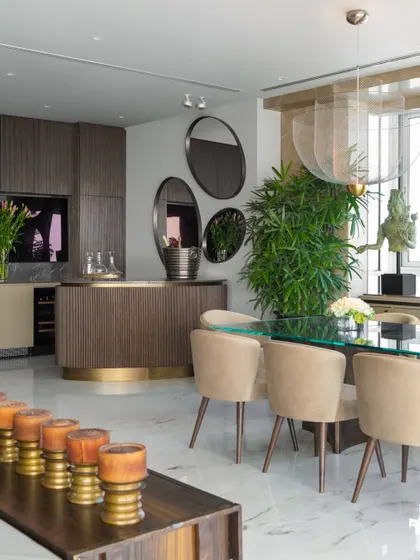 The dining area in the Camellias apartment, set within the larger living space. A custom bar from our Koko collection adds warmth and structure, while a glass-topped table and ethereal Moooi lights create a sense of lightness and poetry.