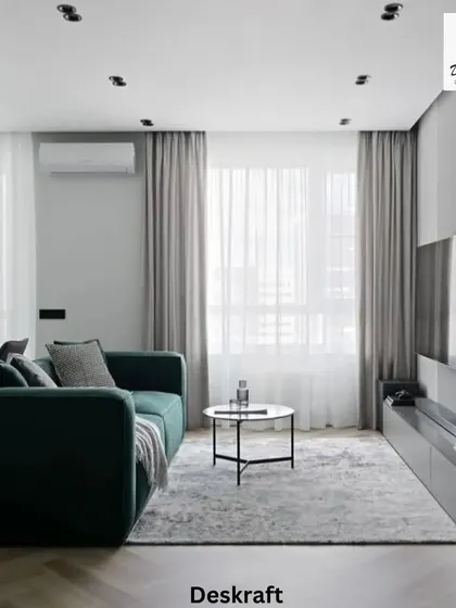 This angle shows the deep green velvet sofa, which adds a touch of luxury and color to the otherwise neutral and grey-toned living space.