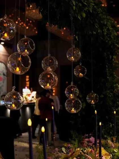 Hanging glass orbs with candles create a soft, romantic glow. I use these details to add layers of light and create an intimate ambiance, especially for evening events.
