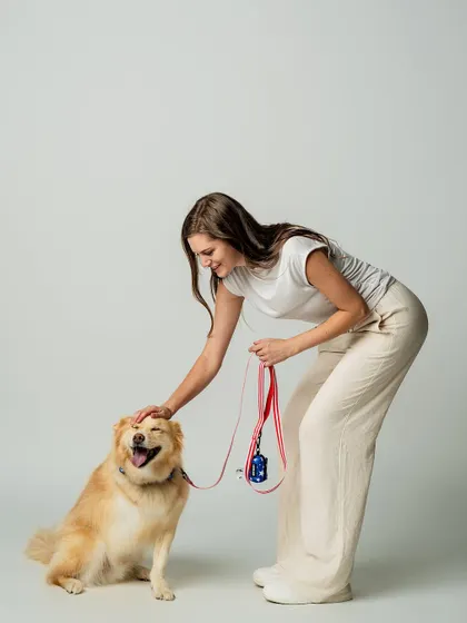 A happy smile and a gentle pat. This image from a brand photoshoot captures the positive connection between humans and pets, which is at the heart of any great pet product.
