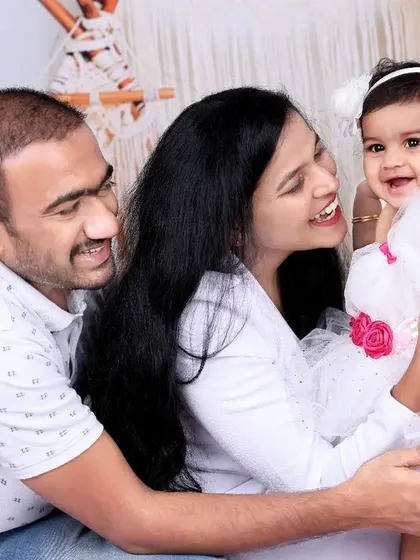 A candid and joyful moment between a mother, father, and their baby girl. The genuine smiles and loving interactions make this family portrait truly special.