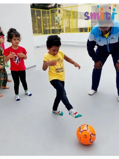 A boy practices kicking a soccer ball. This activity helps develop his gross motor skills and coordination.
